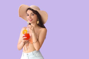 Leylak arkaplanda yaz kokteyli içen genç bir kadın.