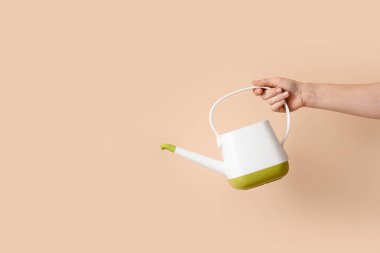 Bej arka planda sulama kutusu olan bahçıvan