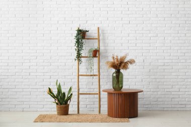 Odanın yanındaki tahta merdiven, masa ve bitkiler.