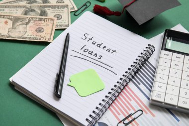 Yeşil arkaplan üzerinde SÜDENT kredileri, dolar banknotları, hesap makinesi ve çizelgeleri olan defter