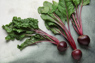 Gri grunge arka planında yaprakları olan taze pancar kökleri