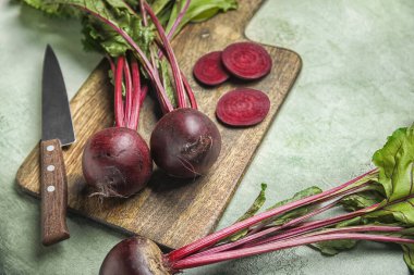 Taze pancar kökü ve gri grunge arka planda bıçak kesme tahtası.