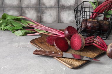 Taze pancar kökü ve gri masada bıçak ile kesme tahtası.