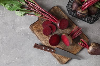 Taze pancar kökü ve gri masada bıçak ile kesme tahtası.