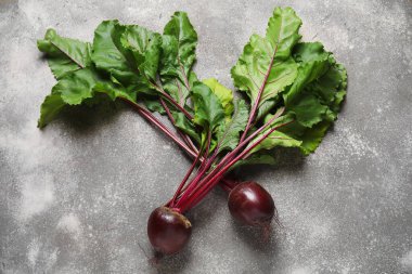 Gri arka planda yeşil yapraklı taze pancarlar