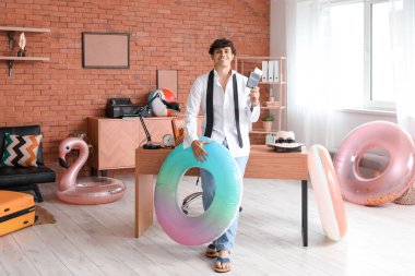 Pasaportlu ve yüzme yüzüklü genç işadamı yaz tatiline hazır.