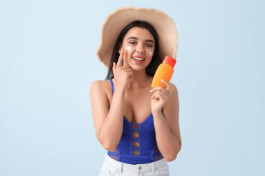 Güneş kremi sürmüş güzel bir genç kadın.