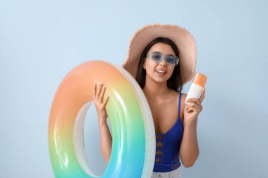 Güneş kremi sürmüş ve yüzme yüzüklü güzel bir genç kadın.