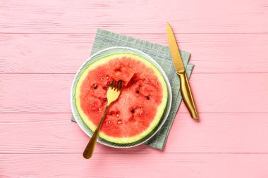 Pembe ahşap arka planda taze karpuz dilimli bir tabak.