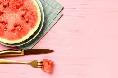 Pembe ahşap arka planda taze karpuz dilimli bir tabak.