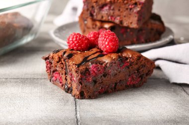 Bir parça ahududulu çikolatalı brownie, gri fayans masasında.