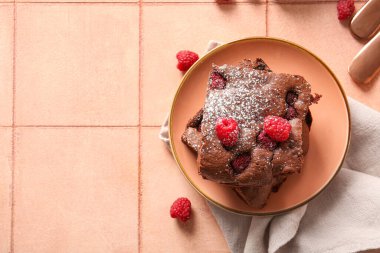 Pembe fayans masasında ahududulu çikolatalı browni.