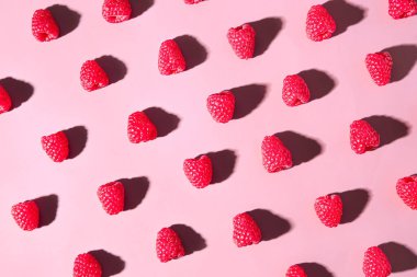 Pembe arka planda bir sürü taze ahududu