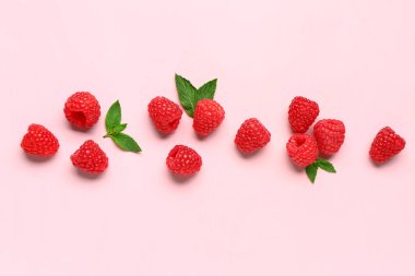 Pembe arka planda bir sürü taze ahududu ve nane.