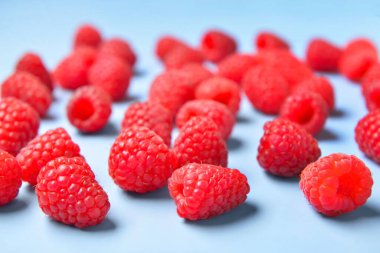 Mavi arka planda bir sürü taze ahududu