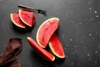 Siyah masanın üzerinde taze karpuz parçaları var.
