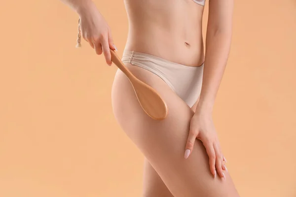Jonge Vrouw Masseren Haar Billen Met Cellulitis Borstel Beige Achtergrond — Stockfoto