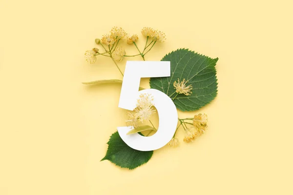 Folhas Verdes Tília Flores Com Número Papel Cinco Fundo Amarelo — Fotografia de Stock
