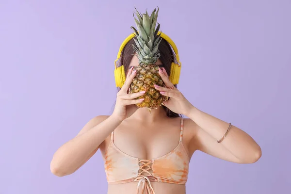 Junge Frau Mit Kopfhörer Mit Ananas Auf Fliederfarbenem Hintergrund — Stockfoto