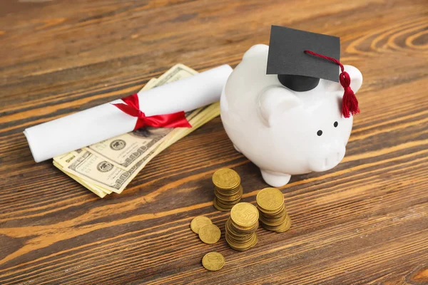 一堆堆的硬币 戴着毕业帽的小猪银行 美元钞票和木制背景的文凭 学生贷款概念 — 图库照片
