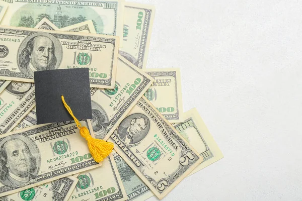 卒業帽子と白い背景にドル紙幣の山 学生ローンの概念 — ストック写真