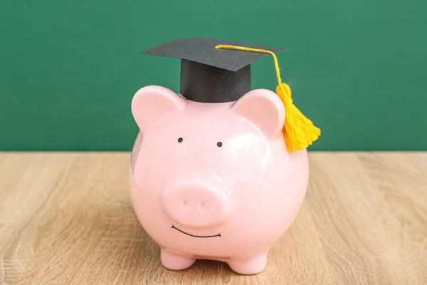 Piggy Bank Graduatie Cap Houten Tafel Tegen Groene Achtergrond Begrip — Stockfoto