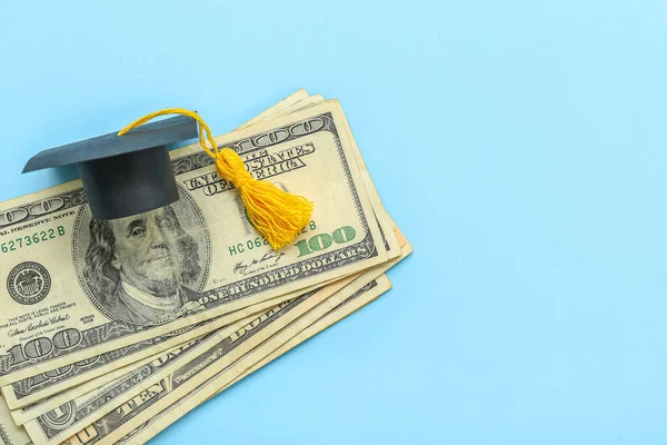 青い背景にドル紙幣と卒業キャップと創造的な組成物 — ストック写真