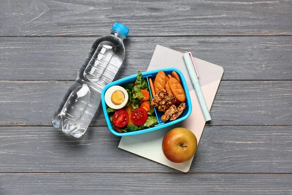 Fles Water Briefpapier Lunchbox Met Lekker Eten Grijze Houten Ondergrond — Stockfoto