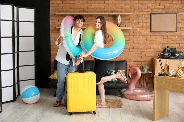 Junges Paar Mit Schwimmringen Und Koffer Bereit Für Den Sommerurlaub — Stockfoto