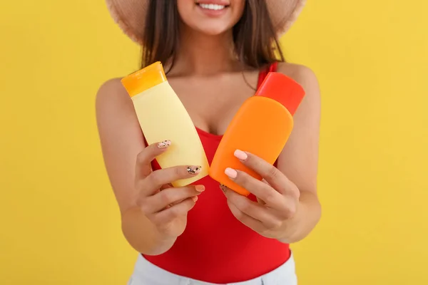 Mulher Bonita Com Garrafas Creme Protetor Solar Fundo Amarelo Close — Fotografia de Stock