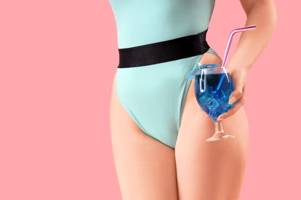 漂亮的性感女人 身穿泳衣 粉色背景的蓝色泻湖鸡尾酒 — 图库照片