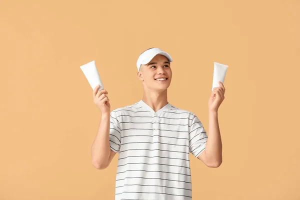 Happy Young Man Bottles Sunscreen Cream Orange Background — Stock Photo, Image
