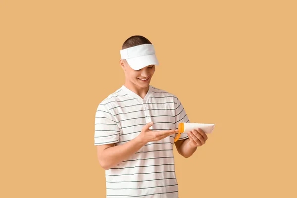 Happy Young Man Applying Sunscreen Cream Orange Background — Stock Photo, Image