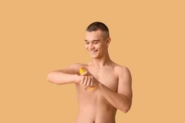 Šťastný Mladý Muž Nanášení Krém Oranžové Pozadí — Stock fotografie