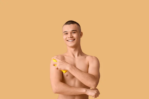 Ευτυχισμένος Νεαρός Άνδρας Που Εφαρμόζει Αντηλιακή Κρέμα Πορτοκαλί Φόντο — Φωτογραφία Αρχείου