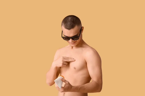 Happy Young Man Sunglasses Applying Sunscreen Cream His Body Orange — Stock Photo, Image