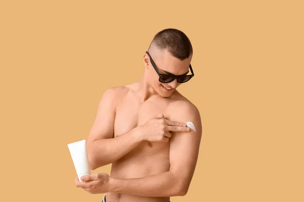 Šťastný Mladý Muž Slunečních Brýlích Nanášení Krém Opalování Jeho Tělo — Stock fotografie