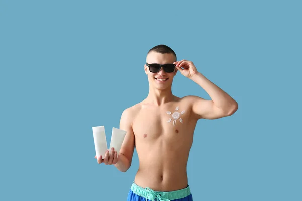 Happy Young Man Sunglasses Bottles Sunscreen Cream Blue Background — Stock Photo, Image