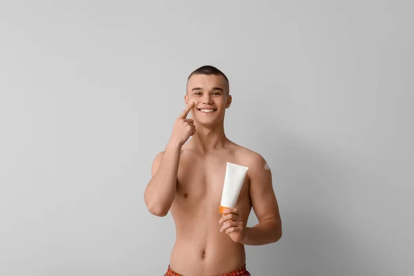 Happy Young Man Applying Sunscreen Cream His Face Grey Background — Stock Photo, Image