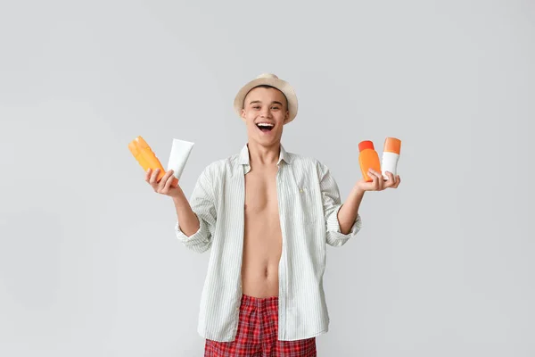 Happy Young Man Different Bottles Sunscreen Cream Grey Background — Stock Photo, Image