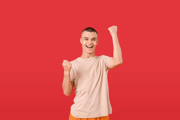 Ευτυχισμένος Νεαρός Άνδρας Αντηλιακή Κρέμα Στο Πρόσωπό Του Κόκκινο Φόντο — Φωτογραφία Αρχείου
