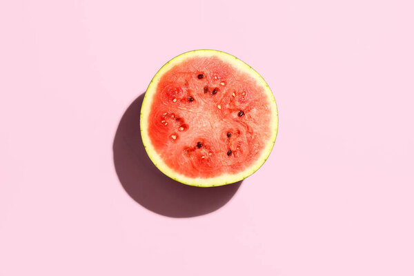 Half of fresh watermelon on pink background