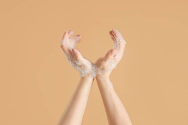 Bej arka planda sabun köpüklü eller