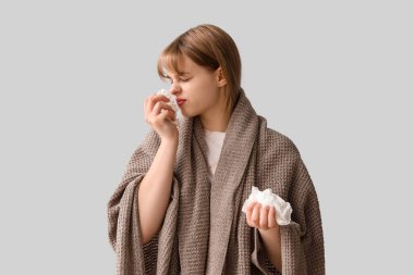 Hafif arka planda mendilleri olan hasta bir genç kız.