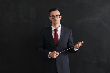 Sınıfta tahtaya yakın duran erkek öğretmen.