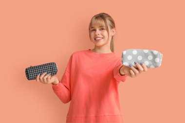 Renkli arka planda kalem kılıfları olan kız öğrenci