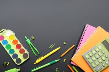 Siyah karatahtanın üzerinde farklı kırtasiye malzemesi olan hesap makinesi