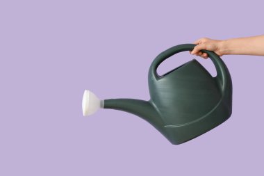 Leylak arka planında sulama tenekesi olan bahçıvan