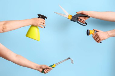 Mavi arka planda bahçe aletleri olan insanlar