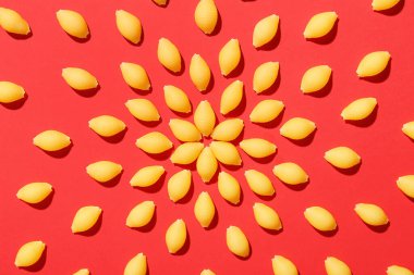 Kırmızı arkaplanda pişmemiş makarna